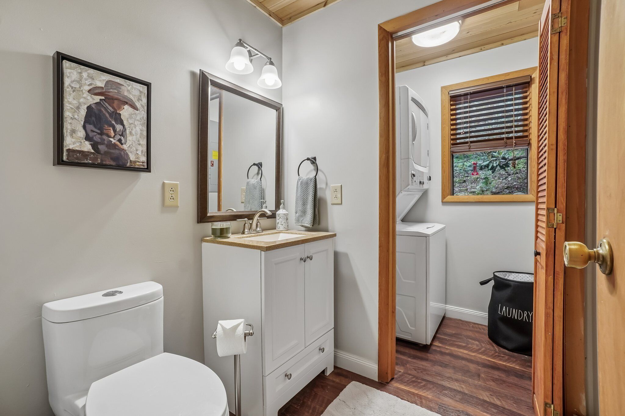 Een badkamer met toilet, wastafel, spiegel en douche.
