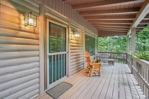 A wooden cabin with a porch, a bench, and a table. - Wolf Laurel Cabin with Hot Tub Near Skiing (Mars Hill)