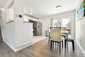 A modern kitchen with built-in appliances, a dining area with a table and chairs, and a large window providing natural light. - ᨒStylish 4BR | Movie Lounge | 10 min to Ft Carsonᨒ (Colorado Springs)