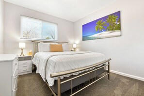 A bedroom with a bed, bedside lamps, a window, and a wall-mounted picture. - ᨒStylish 4BR | Movie Lounge | 10 min to Ft Carsonᨒ (Colorado Springs)