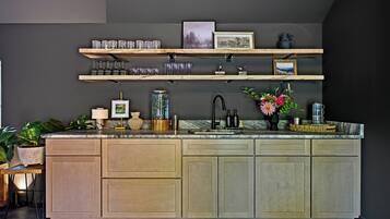 Una cocina con una isla central, armarios de madera y una pared oscura.