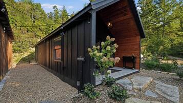 A cabin with a wooden exterior, a visible restroom sign, and a gravel driveway.