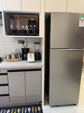 A modern kitchen with a stainless steel refrigerator, a microwave, and a coffee maker. - Charming 2BR apartment in beautiful Nairobi I Private Balcony & City Views (Nairobi)