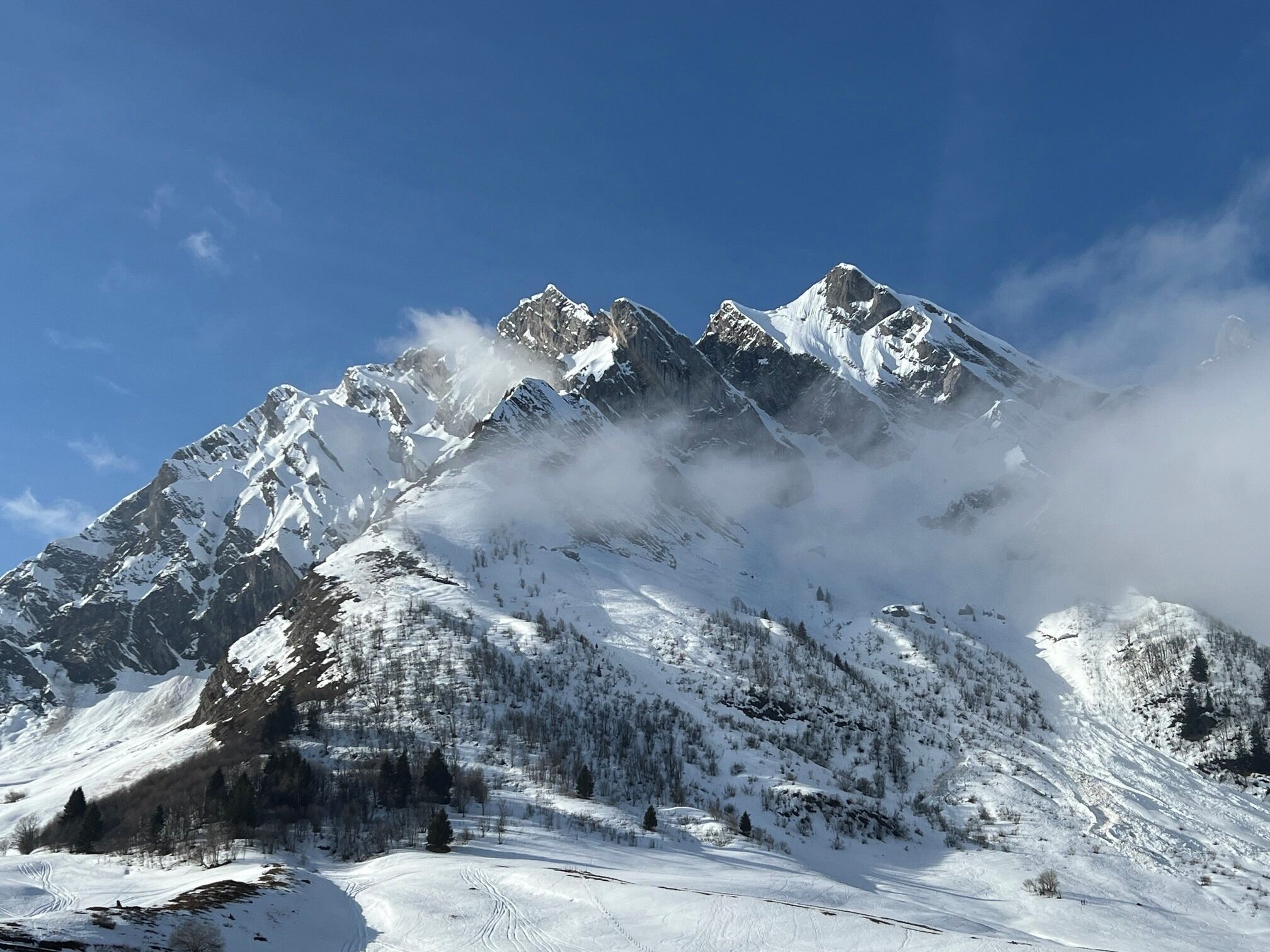 Ein verschneites Gebirge bei strahlend blauem Himmel.