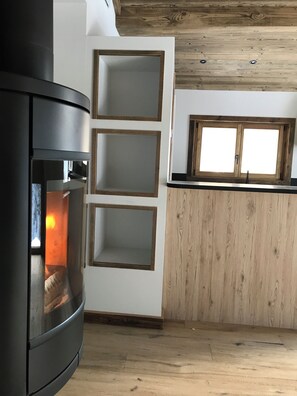 A modern kitchen with a built-in stove, wooden cabinets, and a window above the sink. - 2-bedroom beautiful apartment in charming Alpes village close to Mont Blanc. (La Giettaz)