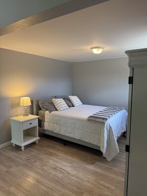 A bedroom with a bed, bedside table, lamp, and a ceiling light fixture. - Serene 1-bedroom house in Littleton perfect for a relaxing getaway (Littleton)
