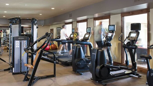 Ein Fitnessstudio mit Laufbändern, Crosstrainern und Gewichtswesen-Geräten.