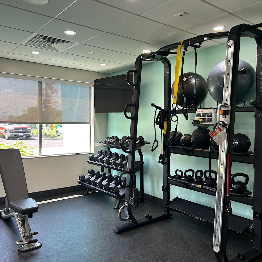 A gym with weightlifting equipment, kettlebells, and dumbbells.