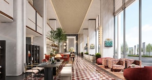 A spacious lobby with a checkered floor, seating areas, and a view through large windows. - Anor And Saffron Tashkent, Curio Collection By Hilton (Tashkent)