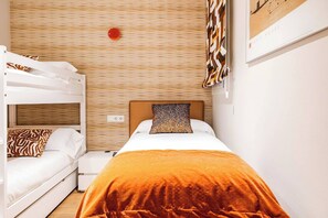 A hotel room with a bunk bed, a single bed, and a patterned wall. - Vive y trabaja wifi rápido Barcelona Sagrada Metro (Barcelona)