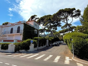 A street with a building featuring a balcony and a row of parked cars. - Cap d'Antibes, view of La Garoupe beach – Sleeps 8 – Garden and terrace (Antibes)
