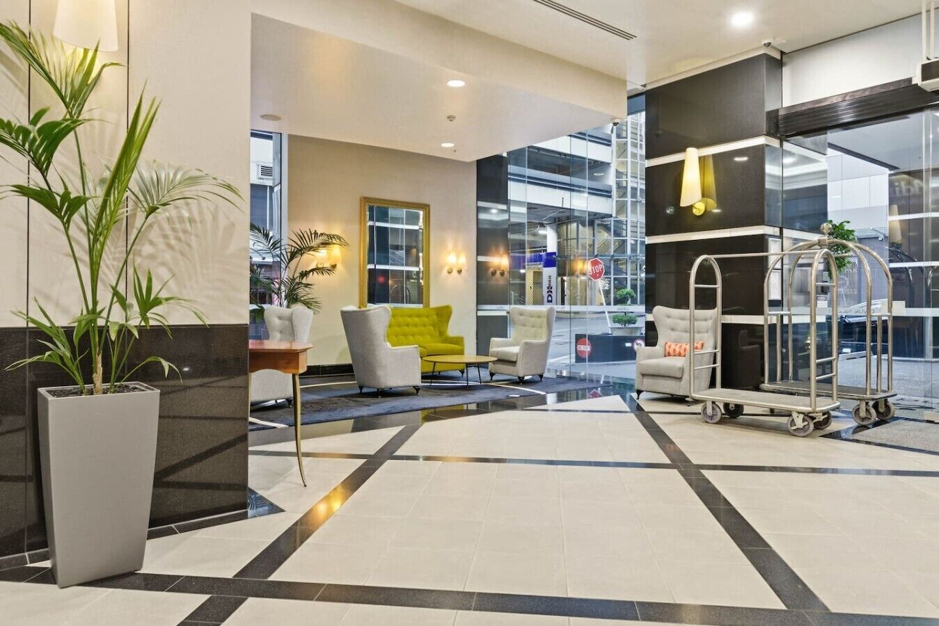 Un hall d’hôtel comprenant un comptoir d’accueil, un espace salon et une vue sur l’extérieur.
