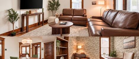 A living room with a flat-screen TV, leather sofas, a coffee table, and a fireplace.