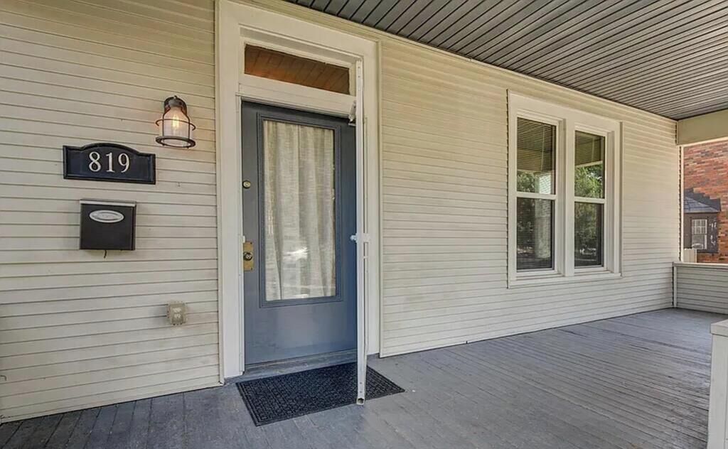 Ein Haus mit Hausnummer 819, einer Haustür und einer Veranda mit Fußmatte.
