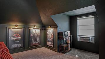 A room with a sloped ceiling, a window, and posters on the wall.