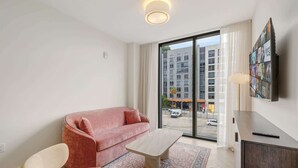 Una sala de estar moderna con un sofá, una mesa de centro y un televisor montado en la pared.