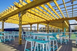 An outdoor seating area with wooden pergola and tables. - Bethany Beach Retreat sleep7 Pools, Pickleball, & Shuttle (Millville)