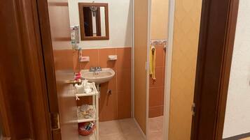 Een douche, handdoeken, zeep, toiletpapier