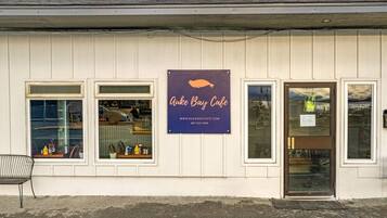 A building with a sign for 'Auke Bay Cafe' and a door with a window.