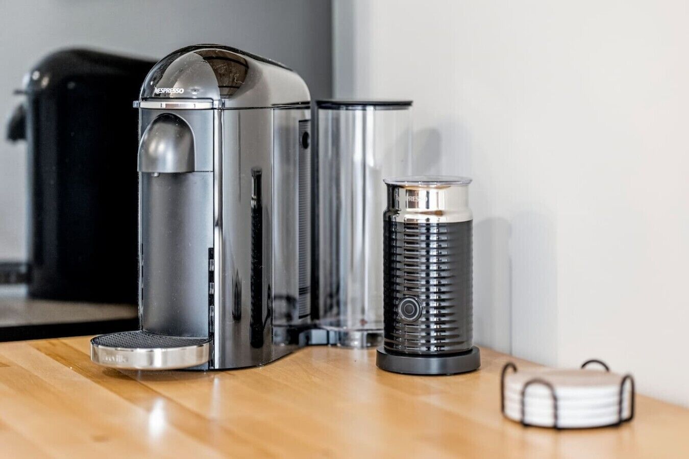 A coffee machine and a coffee grinder on a wooden table.