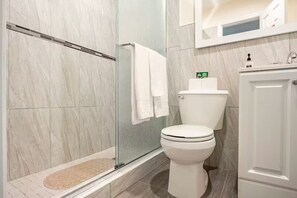 A bathroom with a glass shower enclosure, a toilet, and a sink. - Cozy 1-bedroom studio in soothing Virginia Gardens with AC (Virginia Gardens)