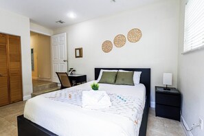 A hotel room with a bed, bedside table, nightstand, and a view of the hallway. - Private studio with its own entrance, minutes from MIA. Parking at the door (Virginia Gardens)