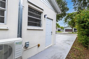 A residential building with a garage, a white door, and a Daikuki inverter. - Private studio with its own entrance, minutes from MIA. Parking at the door (Virginia Gardens)
