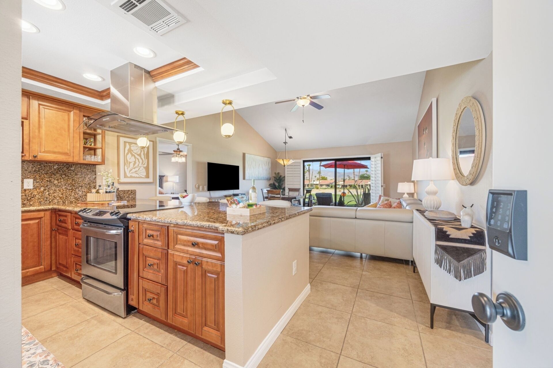 A modern kitchen with granite countertops, wooden cabinets, and a built-in oven.