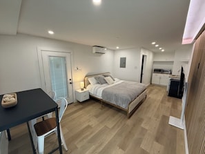 Ein Schlafzimmer mit Bett, Nachttisch, Sessel und einem kleinen Tisch mit einer Schale.