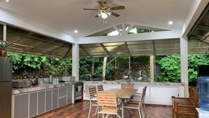 A modern kitchen with a dining area, a ceiling fan, and a view of greenery outside. - A cozy private space in Cuenca Batangas, perfect for relaxing getaways! (Cuenca)