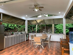 A modern kitchen with a dining area, a ceiling fan, and a view of greenery outside. - A cozy private space in Cuenca Batangas, perfect for relaxing getaways! (Cuenca)
