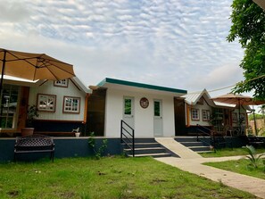 A building with a central entrance, two side wings, and a covered outdoor seating area. - A cozy private space in Cuenca Batangas, perfect for relaxing getaways! (Cuenca)