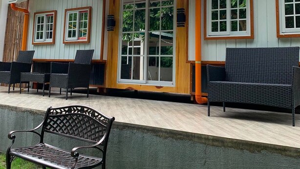 A building with a covered patio area, outdoor seating, and a bench. - A cozy private space in Cuenca Batangas, perfect for relaxing getaways! (Cuenca)