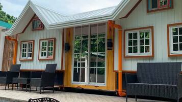 A building with a covered patio area, outdoor seating, and a bench.