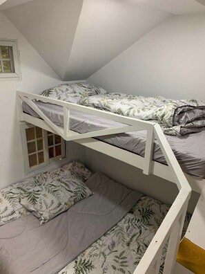 A bunk bed with a window and a door, a small table, and a wall-mounted shelf. - A cozy private space in Cuenca Batangas, perfect for relaxing getaways! (Cuenca)