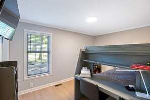 A room with a bunk bed, a desk with a computer, a window with blinds, and a small shelf with books. - Lake it Easy Private Dock with fish cleaning station (Batesburg-Leesville)