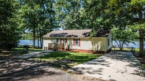 A small cabin with a porch, located near a body of water, surrounded by trees. - Lake it Easy Private Dock with fish cleaning station (Batesburg-Leesville)