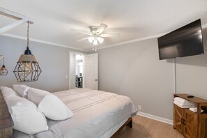 A bedroom with a bed, a ceiling fan, a TV, and a wooden cabinet. - Lake it Easy Private Dock with fish cleaning station (Batesburg-Leesville)