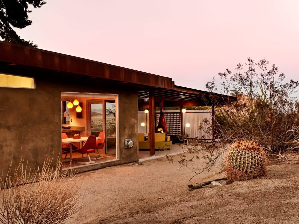 Une maison moderne dotée d’un patio, d’un coin repas et d’une cheminée.