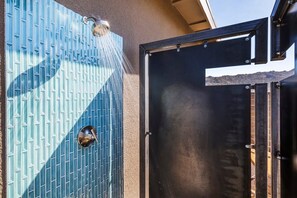 A shower with a blue patterned wall and a metal door. - Shelter 2 By Homestead Modern (Joshua Tree)