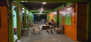 A hallway with seating areas and tables, leading to a staircase.