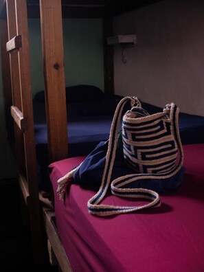 A bunk bed with a striped bag on the lower bunk. - Hostel Bocas Estrella (Bocas del Toro)