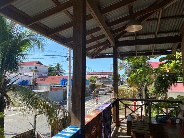 A covered outdoor area with a view of a street and buildings.