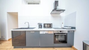 Moderni keittiö, jossa on sisäänrakennettu astianpesukone, uuni ja mikroaaltouuni.