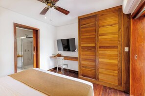 A bedroom with a bed, a desk, a chair, a television, and a wardrobe. - Deluxe 2-Bedroom Family Suite at Villa Luz Do Mar (Jijoca de Jericoacoara)