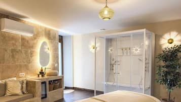A modern bathroom with a glass-enclosed shower, a vanity with a mirror, and a hanging light fixture.