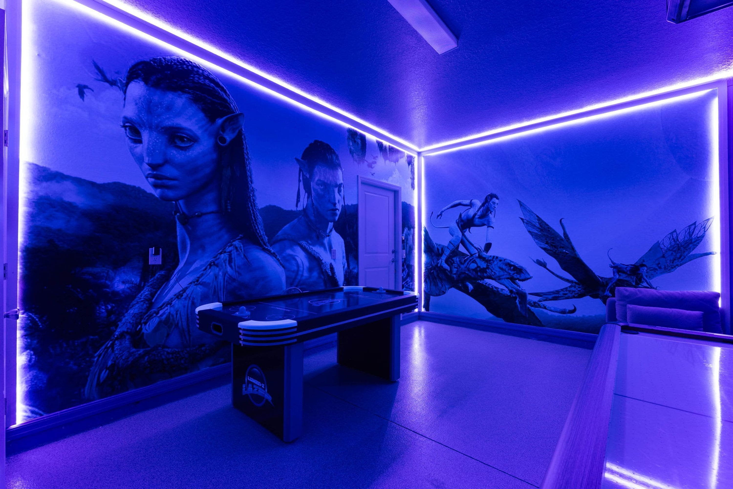 Una habitación con un mural grande en la pared, una mesa y un sofá.