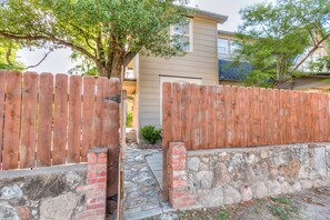 Une porte en bois qui mène à une maison dont les fondations sont faites de pierres.
