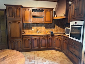 A kitchen with wooden cabinets, a herringbone-patterned floor, and a Bosch oven.