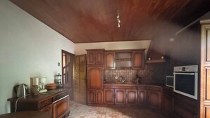 A kitchen with wooden cabinets, a herringbone floor pattern, and a built-in oven.